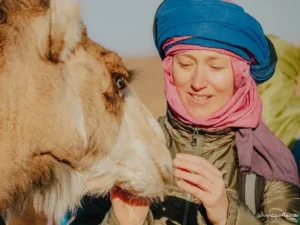 Moment doux entre Sophie et Lachaal, dromadaire accompagnant la retraite YogAnimal pour femmes au Maroc