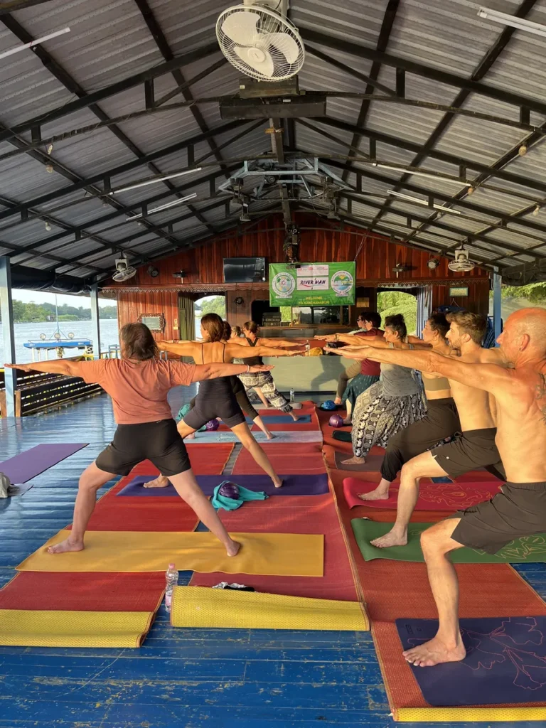 Pratique de yoga unique et originale sur une plateforme flottante sur la rivière Kwaï en Thaïlande.
